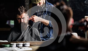 Hipster client getting haircut. Barber with clipper trimming hair on nape of client. Hipster hairstyle concept. Barber