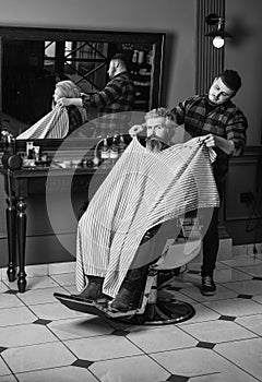 Hipster client getting haircut. Barber and hair stylist dedicate to making you better looking person. Barber with