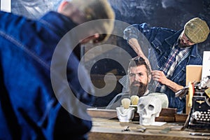 Hipster client getting hairstyle. Reflexion of barber styling hair of bearded client with comb. Barbershop concept. Man