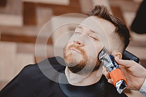 Hipster client man visiting in barber shop shaving beard