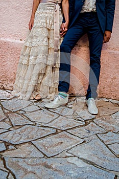 A hipster couple bride and groom with coloured funky socks and a vintage wedding dress