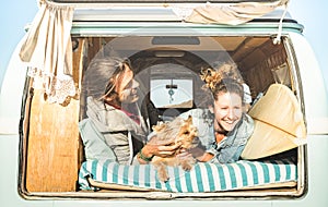 Hipster couple with cute dog traveling together on vintage mini van