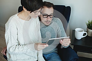 Hipster couple in eyewear enjoying the tablet together