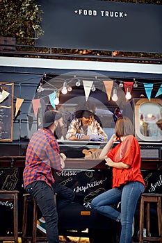 Hipster couple ordering from food truck; Urban lifestyle concept