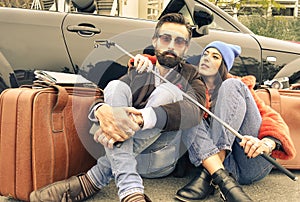 Hipster couple sitting on the street next their cabrio