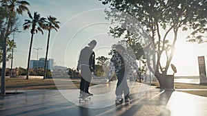 Hipster couple skateboarding. Young couple skateboarding in the street. Couple having fun with skateboard on beach
