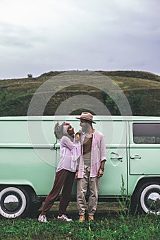 Hipster couple staying near retro mini van
