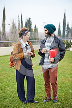 Hipster couple talking and drinking coffee to go