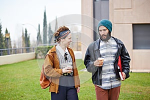 Hipster couple talking and drinking coffee to go