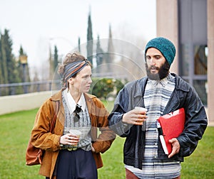 Hipster couple talking and drinking coffee to go