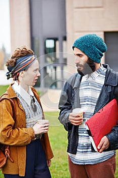 Hipster couple talking and drinking coffee to go