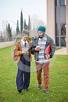 Hipster couple talking and drinking coffee to go