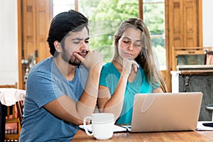 Hipster couple thinking about online offer at computer