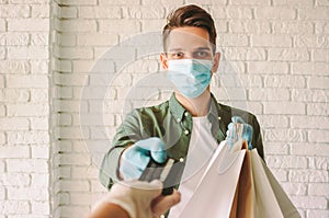 Hipster courier giving shopping bags and check out customer