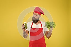 Hipster decide what to choose. healthy eating and dieting concept. cook hold fresh salad and smoothie in bottle. organic