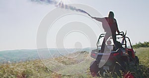 Hipster friends having fun with color flares and while driving off road car in nature. Adventurous spirit and freedom