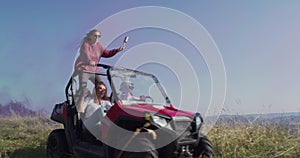 Hipster friends on road trip driving off road car in nature and having fun