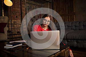 Hipster girl in glasses checking e-mail via notebook device
