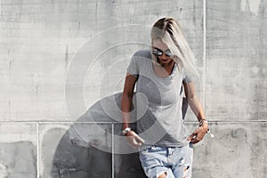 Hipster girl in gray t-shirt over street wall