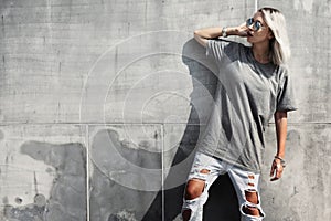 Hipster girl in gray t-shirt over street wall