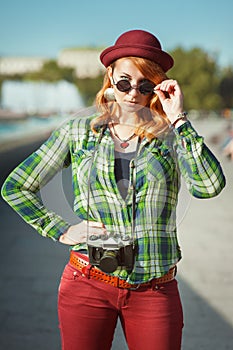 Hipster girl in hat and sunglasses with retro camera