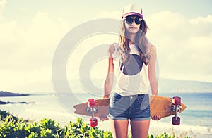 Hipster girl with skate board wearing sunglasses