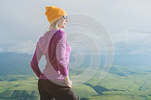 A hipster girl in a straw hat and glasses on the nature landscape