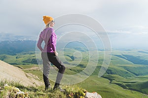 A hipster girl in a straw hat and glasses on the nature landscape