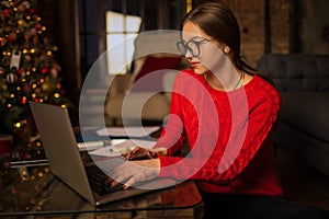 Hipster girl in stylish glasses professional fashion magazine editor checking e-mail on laptop computer