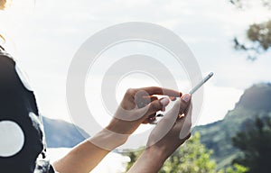 Hipster girl texting message on smartphone mobile close up, view tourist hands using gadget phone on device on background perspect photo