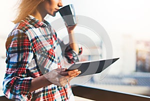 Hipster girl using tablet technology and drink coffee, girl person holding computer on background sun city, female hands texting m