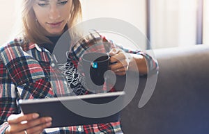 Hipster girl using tablet technology in home atmosphere, girl person holding computer with blank screen on background bokeh