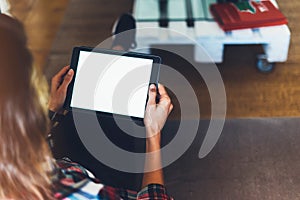 Hipster girl using tablet technology in home atmosphere, girl person holding computer with blank screen on background bokeh, femal