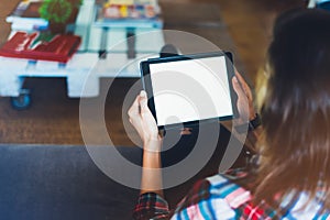 Hipster girl using tablet technology in home atmosphere, girl person holding computer with blank screen on background bokeh, femal