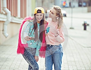 Hipster girlfriends taking a selfie in urban city