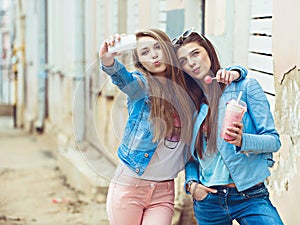 Hipster girlfriends taking a selfie in urban city