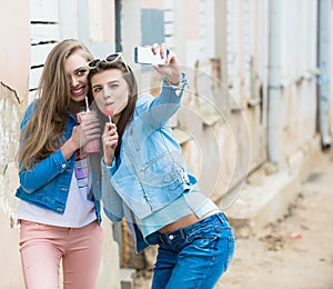 Hipster girlfriends taking a selfie in urban city