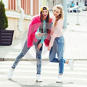 Hipster girlfriends taking a selfie in urban city