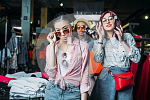 Hipster girls choosing clothes in boutique, fashion shopping girls concept