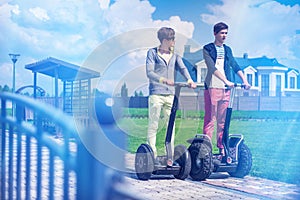 Hipster guys enjoy outdoors on the segway