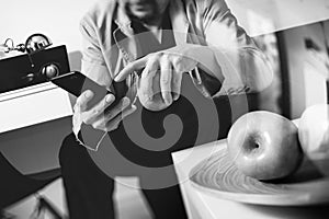 hipster hand using smart phone for mobile payments online business,sitting on sofa in living room,holding green apples in wooden