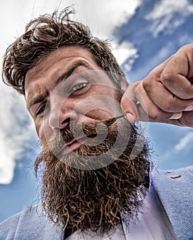 Hipster handsome attractive guy close up. Man bearded hipster twisting mustache sky background. Ultimate moustache