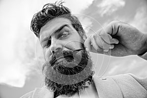 Hipster handsome bearded attractive guy close up. Man bearded hipster with mustache sky background. Ultimate beard and