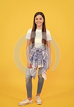 hipster happy child in casual clothes full length on yellow background