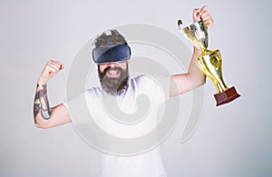 Hipster on happy face squeezing fist as successful gesture. Guy with head mounted display won in virtual game. Man with