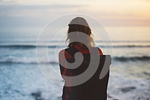 Hipster hiker tourist with backpack looking of amazing seascape sunset on background blue sea, photographer enjoying ocean horizon