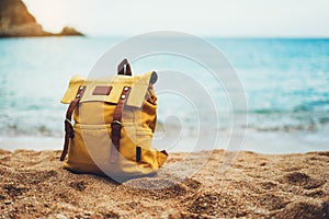 Hipster hiker tourist yellow backpack closeup on background blue sea enjoying sunset ocean horizon