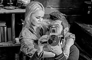 Hipster holding vintage camera while girlfriend hugs him. Vintage photographer concept. Couple in love spend romantic