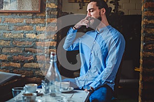 Hipster imitating cell phone conversation in a cafe