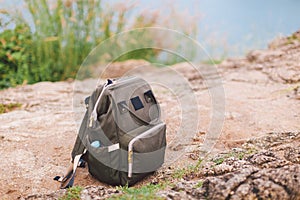 Hipster khaki backpack closeup Front view tourist traveler bag on footpath background . Backpack resting on the ground